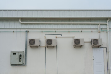 Air compressor or air condenser unit located on support outside building to heat released...