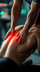 Therapist giving deep tissue massage on muscular male back with red pain point, recovery concept