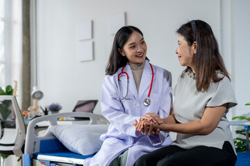 Obraz premium Doctor is giving moral support to her patient by holding her hand and smiling at her