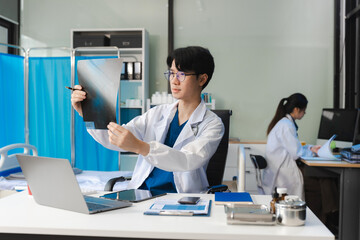 Doctor working on digital tablet healthcare doctor technology tablet using x-ray film analyzed the results of medical reports.