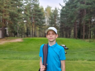 Young golfer ready to play on a lush green course with tall trees in the background