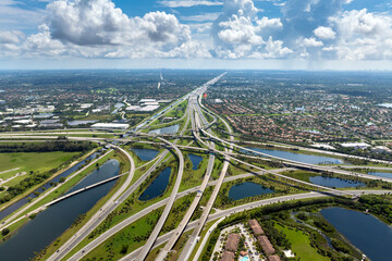 Aerial view of American freeway intersection with fast driving cars and trucks in Miami, Florida....