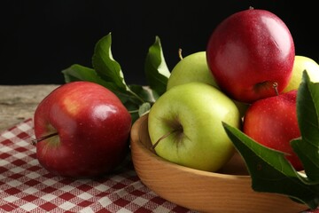 Ripe apples and green leaves on table, closeup