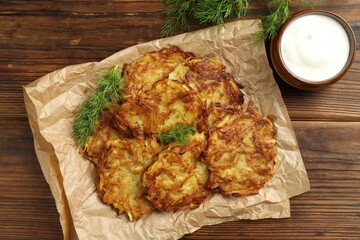 Delicious potato pancakes served on wooden table, flat lay