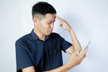 confused Asian man looking at cellphone