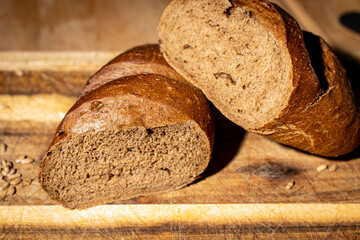 Pears stewed in red wine are poured with sauce on a black mica plate on a dark background.