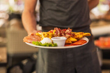 Chef Serving Delicious Breakfast Platter with Eggs and Bacon