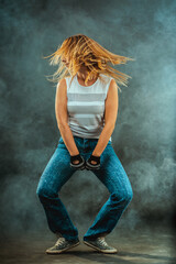 A dancer showcases her talent in a foggy environment