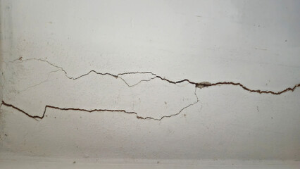 Cracks on the white concrete wall