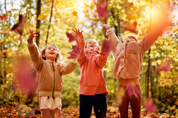 Group Of Young Children having fun on Autumn Forest