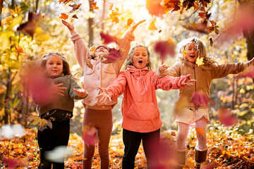 Group Of Young Children having fun on Autumn Forest