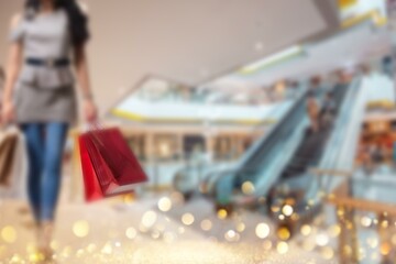 Blurred image of a person carrying shopping bags while walking through a shopping mall in China.