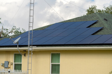 Fototapeta premium Residential house with rooftop covered with solar photovoltaic panels for producing of clean ecological electrical energy in suburban rural area. Concept of autonomous home