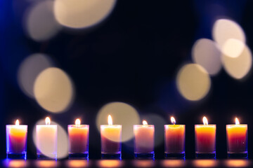 Burning candle on black background with bokeh. Memorial Day.