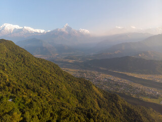 A breathtaking view of a mountain range with snow-capped peaks and a lush green valley.
