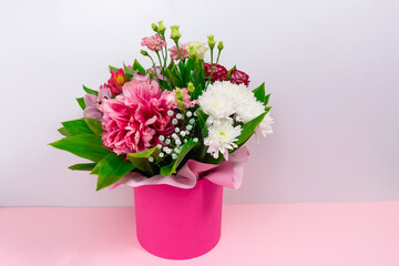 Big beautiful bouquet of  various natural flowers in a pink gift box. White background.