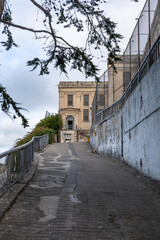 View of a pathway leading to a historic building on Alcatraz Island, showcasing its iconic architecture and infamous prison walls.