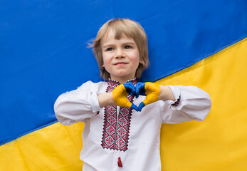 children's hands painted in the colors of the Ukrainian flag are folded in the shape of a heart. patriotism. children against war. Support Ukraine. Gratitude for global support for Ukraine