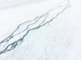 Aerial view of cracked grey surface with intricate patterns.
