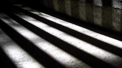 Parallel lines of light cast by a window on a concrete floor.