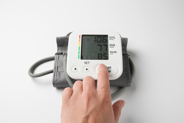 Man using blood pressure measuring device on white background, closeup
