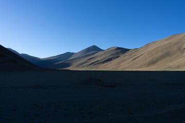 A vast desert landscape with rolling hills under a clear sky