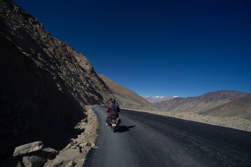 Motorcyclist riding through a mountain pass on a clear day © Marcel