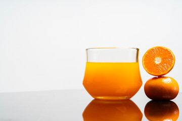 Vertical image of delicious freshly squeezed orange juice in the glass from organic oranges isolated on white background with copy space