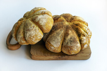 Unusual homemade handmade breads in the shape of a pumpkin on a white background. Space for text.