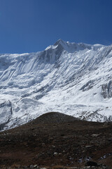 Fototapeta premium A stunning view of a snow-covered mountain peak under a clear blue sky.