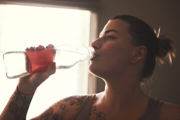 Fitness, drinking and woman with water in home with break for workout, training or health...