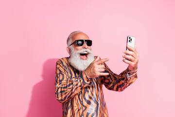 Photo of positive funky cheerful man wear stylish print clothes speak modern gadget video talk...