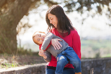Fototapeta premium A woman is holding a baby in her arms