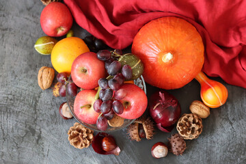 Comfort food ingredients on a table. Colorful still life with pumpkin, apples, nuts and flowers. Autumn harvest concept. 