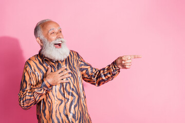 Portrait of funky aged man indicate finger empty space laugh tiger print shirt isolated on pink color background