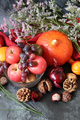 Comfort food ingredients on a table. Colorful still life with pumpkin, apples, nuts and flowers. Autumn harvest concept. 