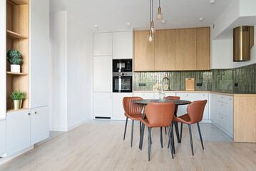Dining room with kitchen in new apartment. Modern interior with chairs with table and white furniture and stylsih tile at home. Design architecture.