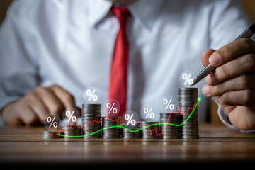 Businessman putting down money, pointing with pen and showing candlestick symbol for investing, finance, saving money, interest rate or dividend investment, business growth concept.