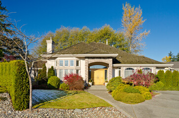 luxury house with garage door, big tree and nice Fall Foliage landscape in Vancouver, Canada