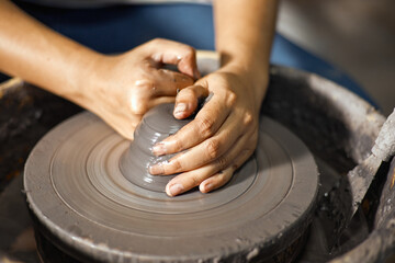 Hands of craftsman artist working on pottery wheel