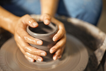 Hands of craftsman artist working on pottery wheel