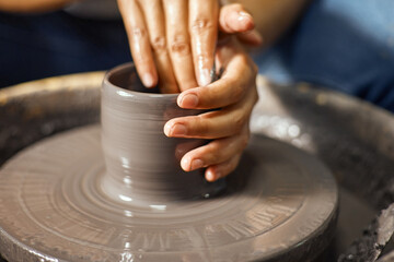 Hands of craftsman artist working on pottery wheel