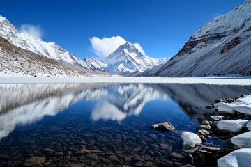 Fototapeta premium Mount Everest covered in a blanket of snow during winter, the scene serene and quiet, with soft white snow smoothing out the jagged rocks and the peak shrouded in clouds