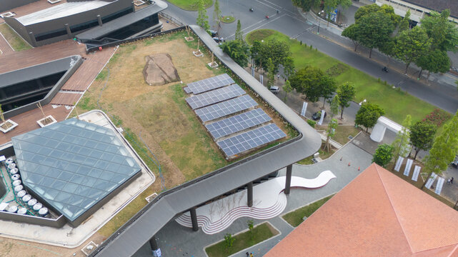 The view showcases solar panels on a rooftop alongside a landscaped garden in an urban area