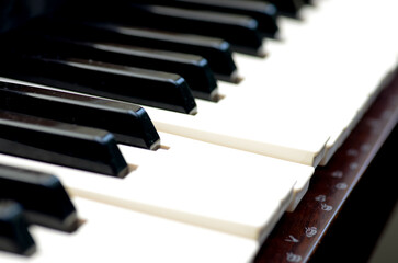 The image shows a close-up of a piano keyboard, with alternating black and white keys.