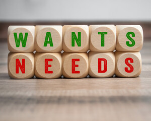Cubes, dice or blocks with metapher wants or needs on wooden background