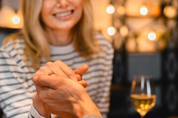 Smiling beautiful woman holding her future husband`s hand with engagement ring on a date. Future family, new beginnings, she said yes. Proposal concept