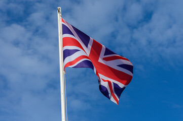 British flag waving under a clear blue sky during a sunny day in the United Kingdom