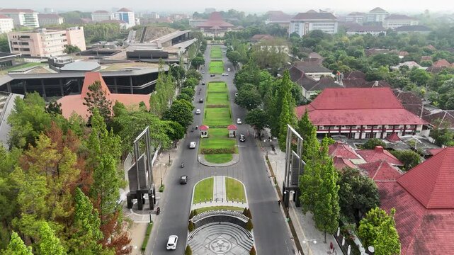 Explore the Universitas Gadjah Mada of a busy street adorned with lush trees and charming red roofs