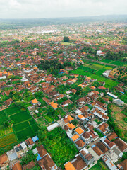 Obraz premium Aerial drone view of Muslim Balinese settlements near green paddy fields scenery at Gelgel Village in Klungkung, Bali, Indonesia.